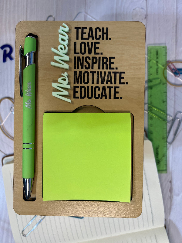 Wooden desk organizer with green pen, sticky notes, and motivational quote on a blurred background