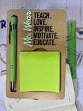 Wooden desk organizer with green pen, sticky notes, and motivational quote on a blurred background