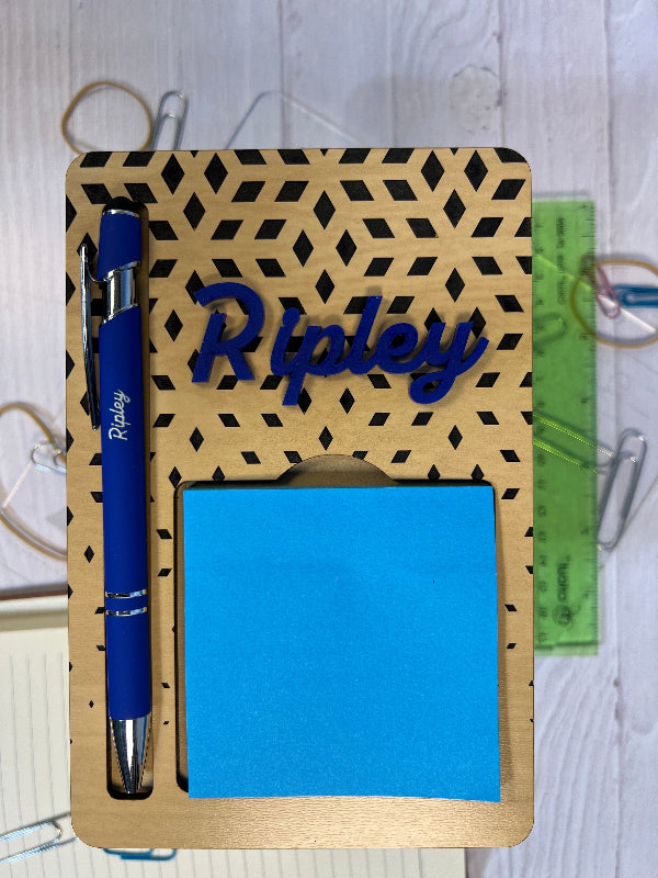 Holder with geometric cover, blue pen, and sticky notes on a white surface From She Shed Designs