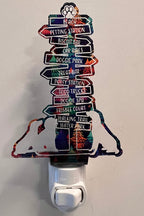 Handcrafted acrylic nightlight with a dog trail design, featuring multiple directional signs, plugged into a wall outlet. From She Shed Designs.