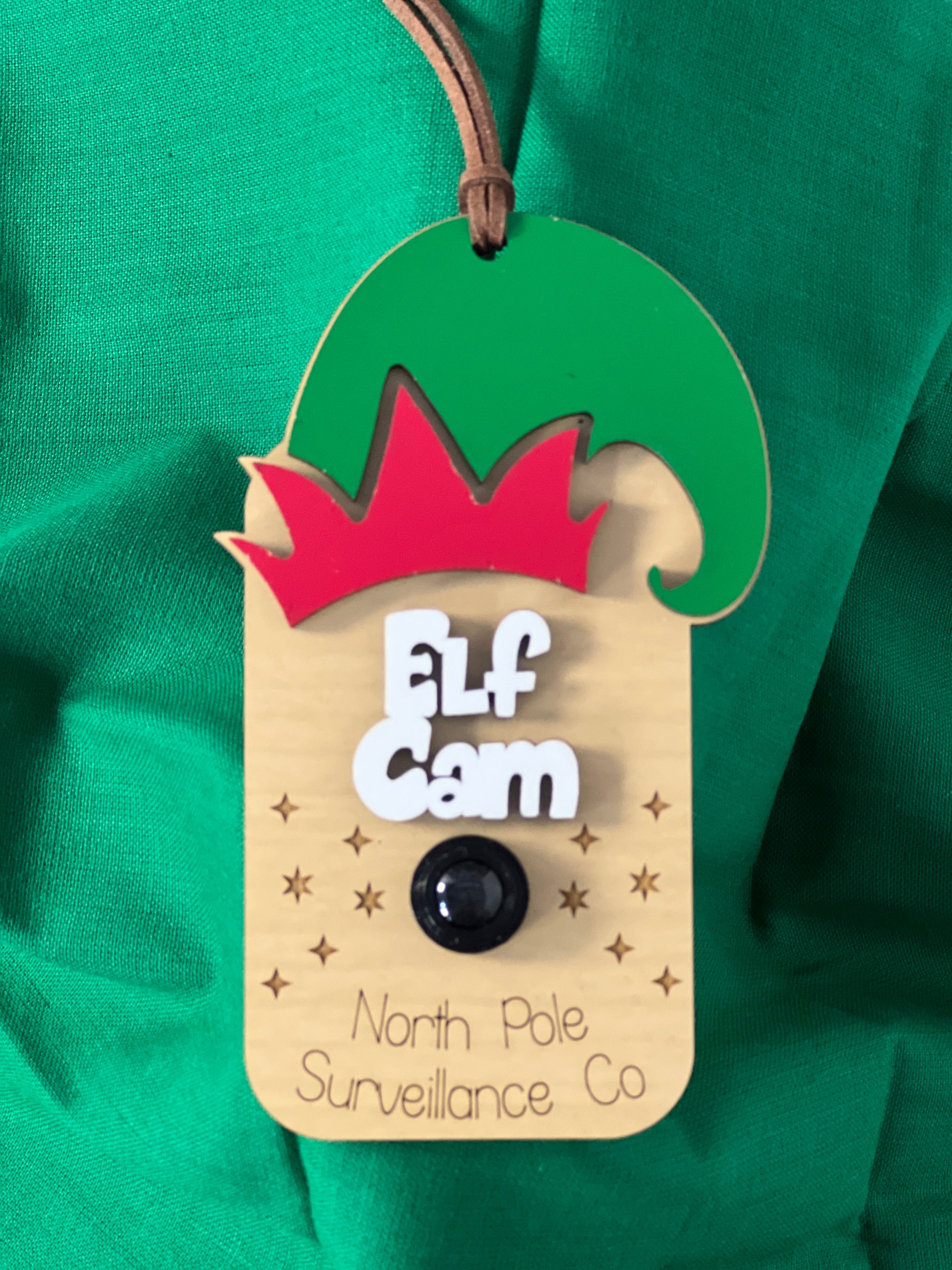 Elf Cam device with green hat and red top on a green background