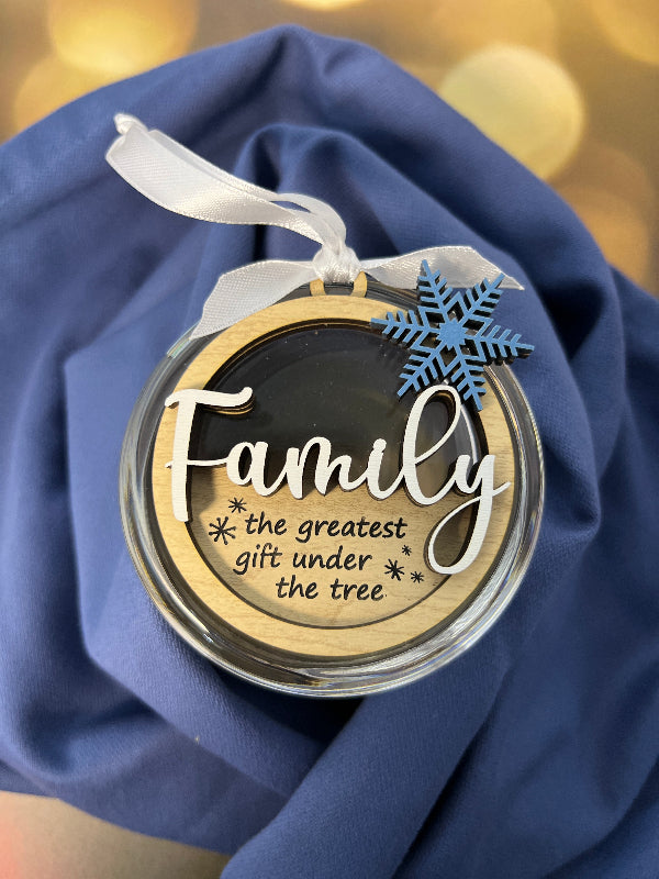 Decorative ornament with 'Family is the greatest gift under the tree' text on a blue fabric background. From She Shed Designs