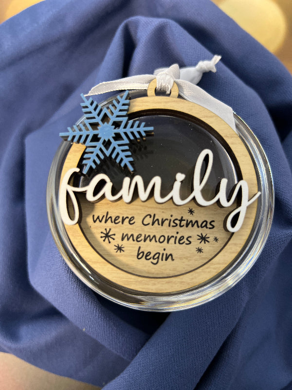 Decorative locket with 'Family where Christmas memories begin' text on a blue fabric background. From She Shed Designs