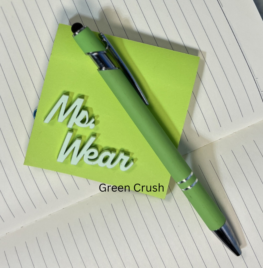 Green pen and notebook with 'Mrs. Wear' branding on a white surface. From She Shed Designs