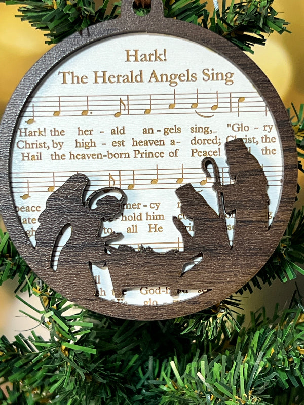 Decorative wooden ornament with angel silhouette and musical notes on a green wreath background. From She Shed Designs
