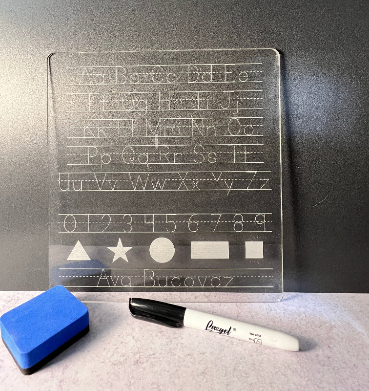 Stencil with letters and shapes on a dark surface with a marker and eraser.