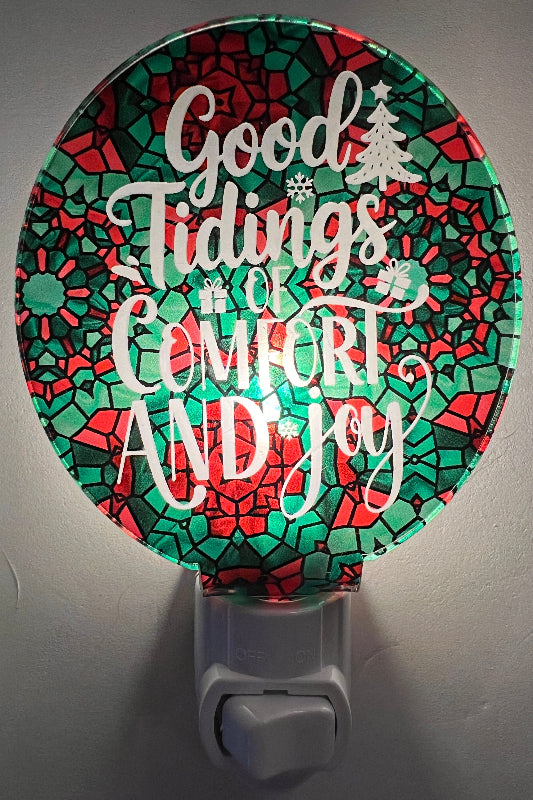 Handcrafted acrylic nightlight with a festive 'Good Tidings of Comfort and Joy' message, featuring red and green colors and a tree. From She Shed Designs.
