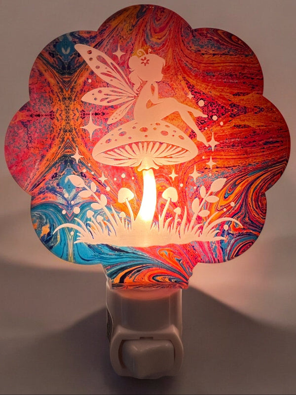 Handcrafted acrylic nightlight featuring a fairy with a mushroom design in a Pink and blue paint pour. From She Shed Designs.