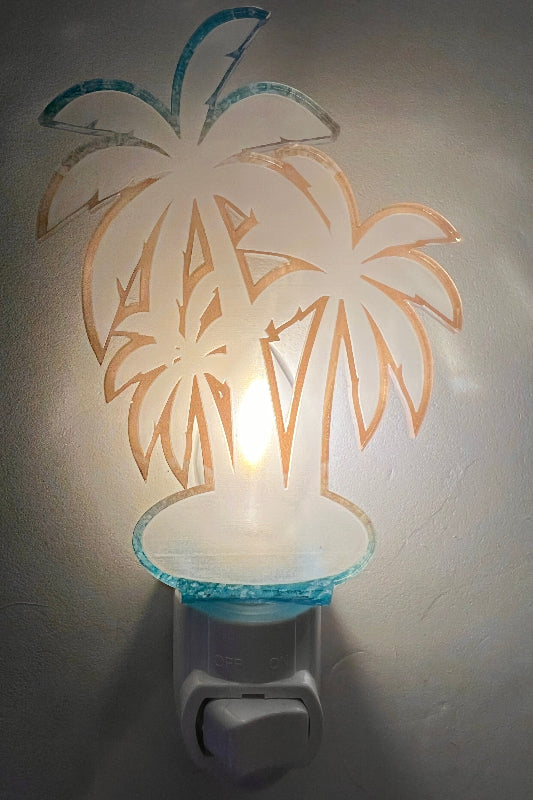 Handcrafted acrylic nightlight with a palm tree design, mounted on a wall. From She Shed Designs.
