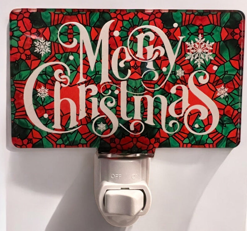 Handcrafted acrylic nightlight with a 'Merry Christmas' design, featuring a red and green patterned background with white cursive text, placed on a white surface. From She Shed Designs.