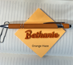 Brown pen with 'Bethanie Orange Haze' on a yellow card on lined paper. From She Shed Designs