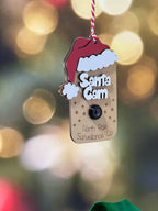 Decorative tag with 'Santa's Cam' text on a blurred festive background From She Shed Designs