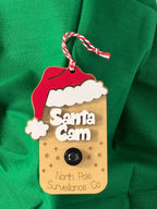 Santa Cam tag with a camera on a green fabric background From She Shed Designs