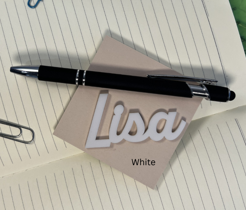 Black pen on a piece of paper with 'Lisa' written on it, placed on a lined notebook. From She Shed Designs